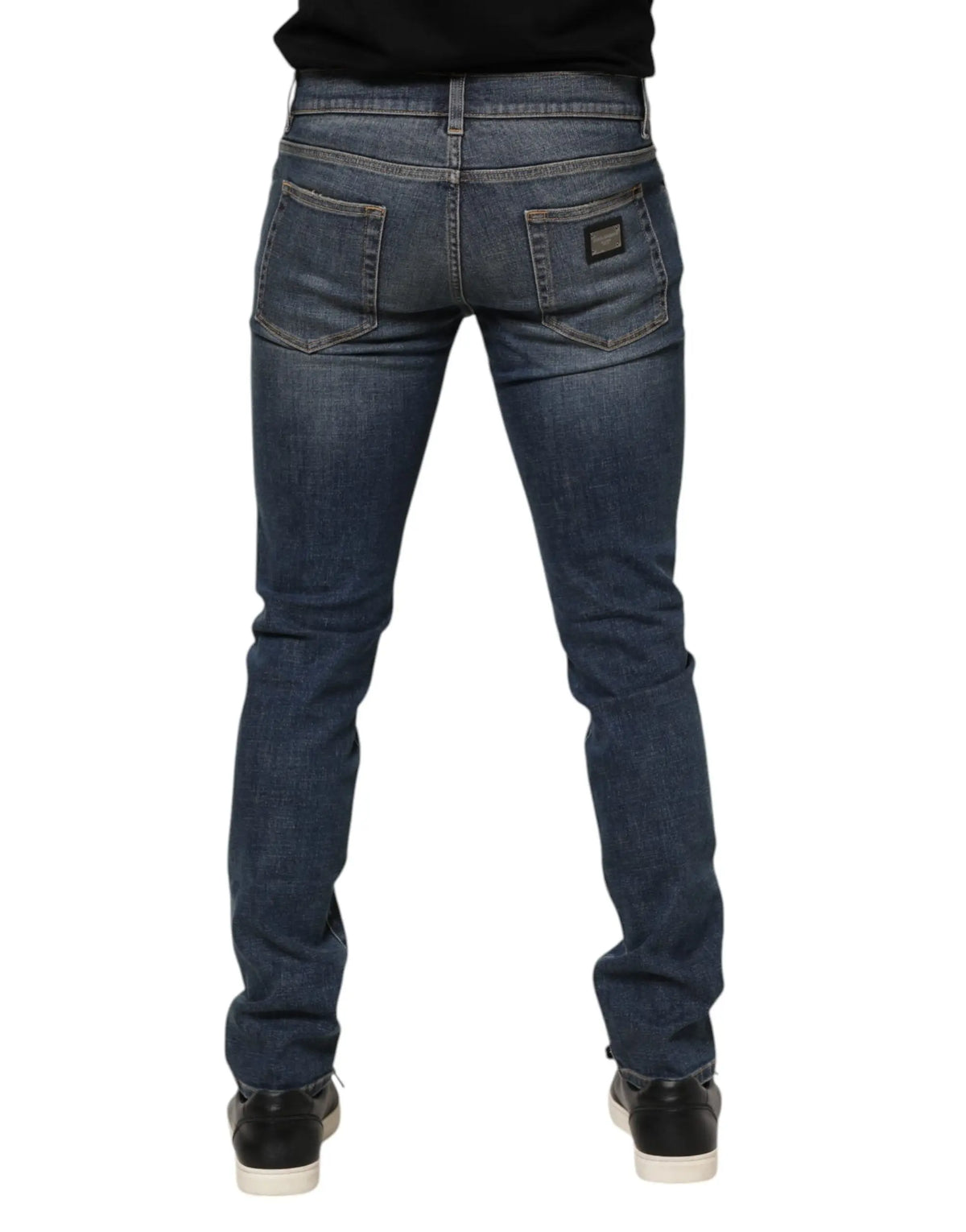 Jeans slim en denim bleu foncé avec délavage subtil et patch cuir noir à lacarrière droite dolce & gabbana