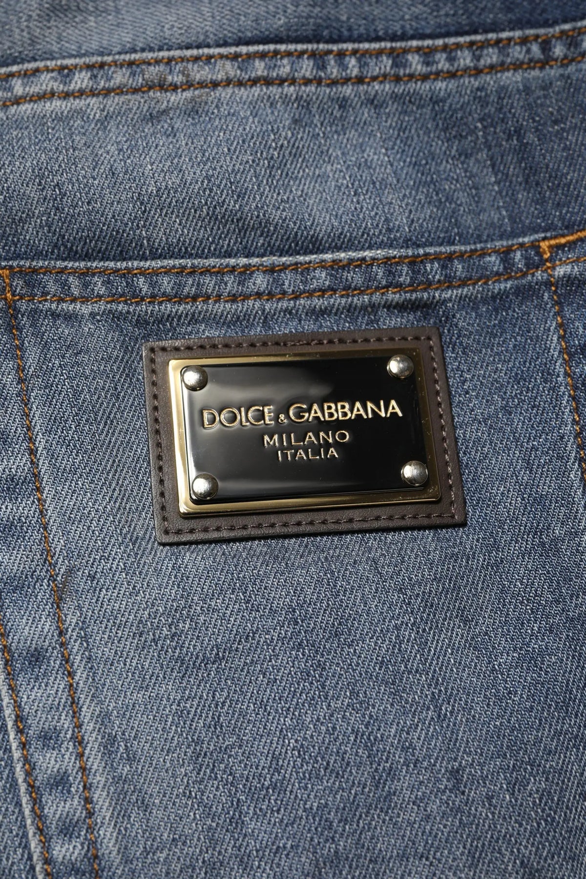 Jeans bleu foncé en denim avec patch en cuir noir et rivets argentés dolce & gabbana milano italia vue arrière