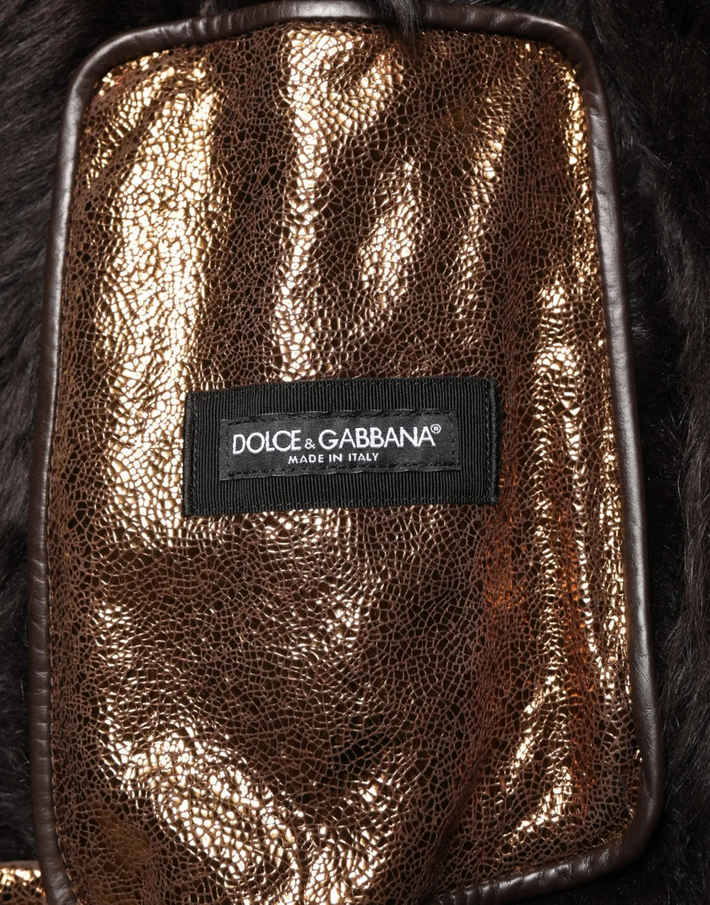 Une pochette métallique dorée scintillante en cuir craquelé avec coutures marron foncé pour veste biker homme dolce & gabbana bronze cuir fourrure zippée intégrale