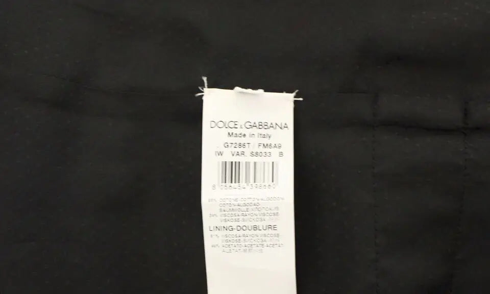 Étiquette blanche rectangulaire dolce & gabbana made in italy cousue sur tissu foncé dun gilet en coton marron