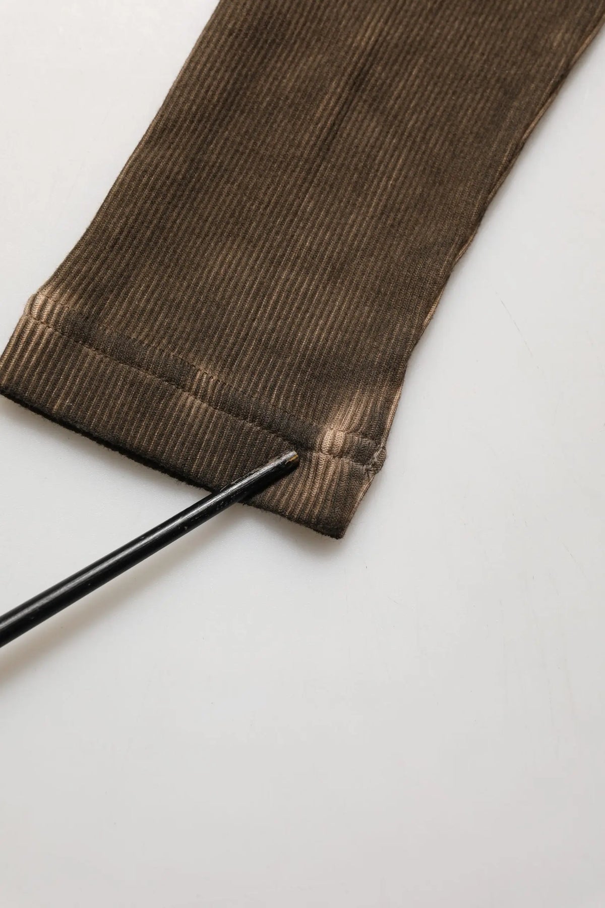 Manche en velours côtelé marron avec texture côtelée et légère décoloration au poignet du pull henley Dolce & Gabbana en coton