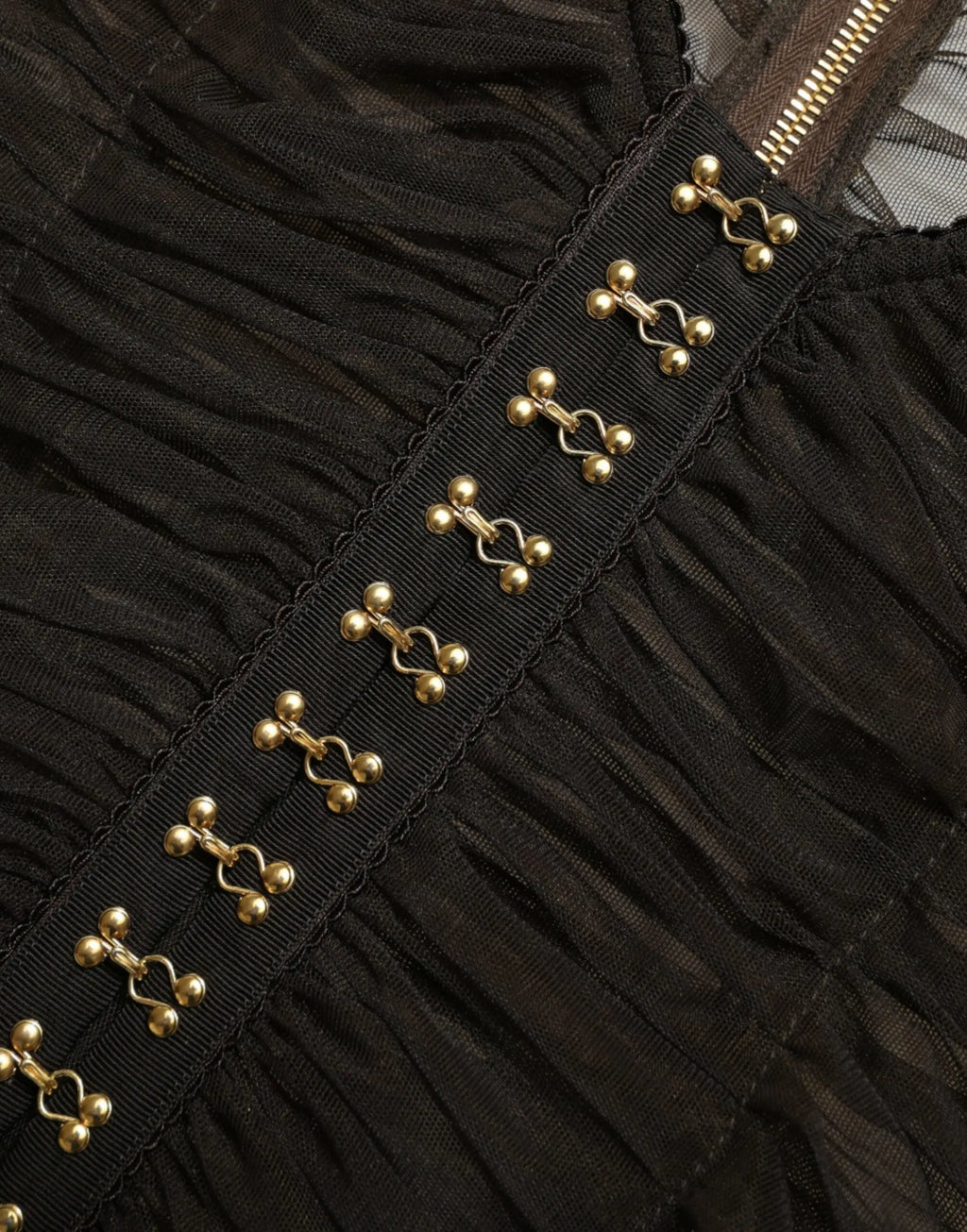 Robe en tissu noir froncée avec rangée de fermoirs métalliques dorés sur la couture latérale pour dolce gabbana
