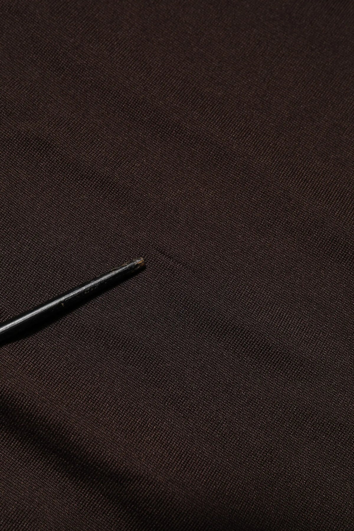 T shirt dolce & gabbana à col rond en soie marron avec manches courtes posé sur tissu noir texturé avec stylo noir