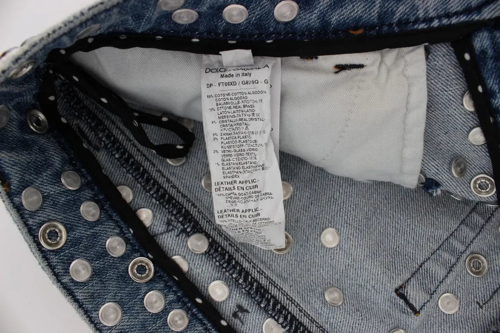 Jean bleu en denim dolce & gabbana avec studs argentés sur la ceinture et étiquette blanche de soin à l’intérieur
