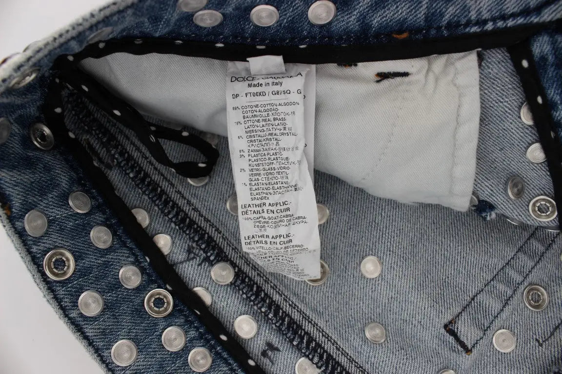 Jean bleu en denim dolce & gabbana avec studs argentés sur la ceinture et étiquette blanche de soin à l’intérieur