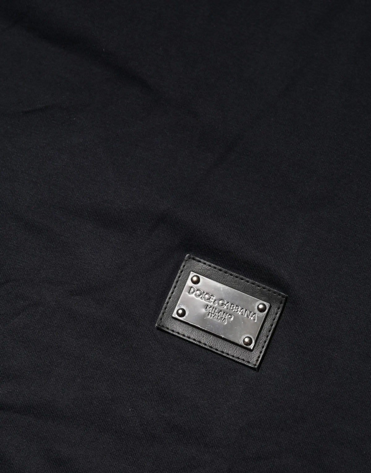 Patch en cuir noir avec plaque métal argentée dolce gabbana milano sur t-shirt coton bleu foncé col rond