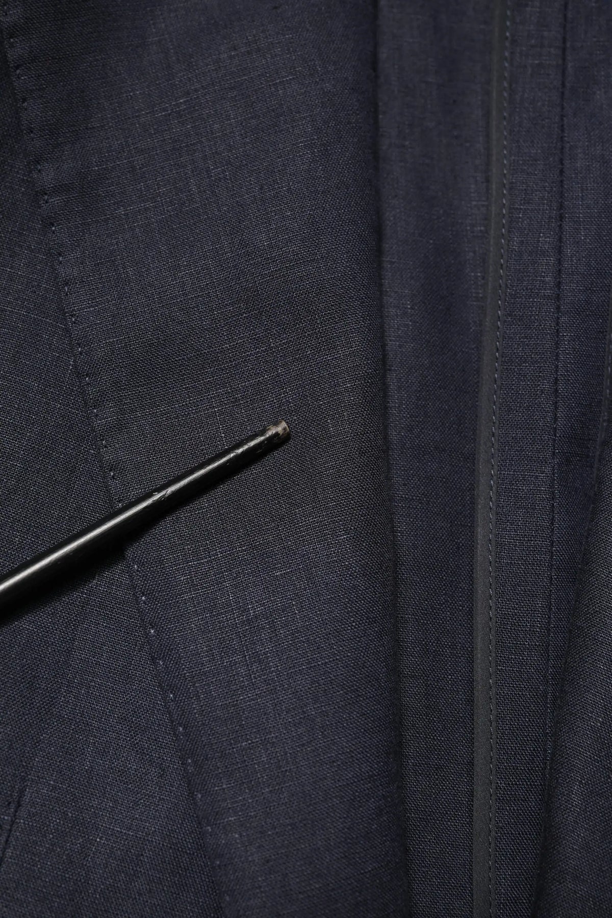 Stylo noir posé sur tissu texturé bleu marine foncé du blazer homme dolce & gabbana bleu nuit simple boutonnage