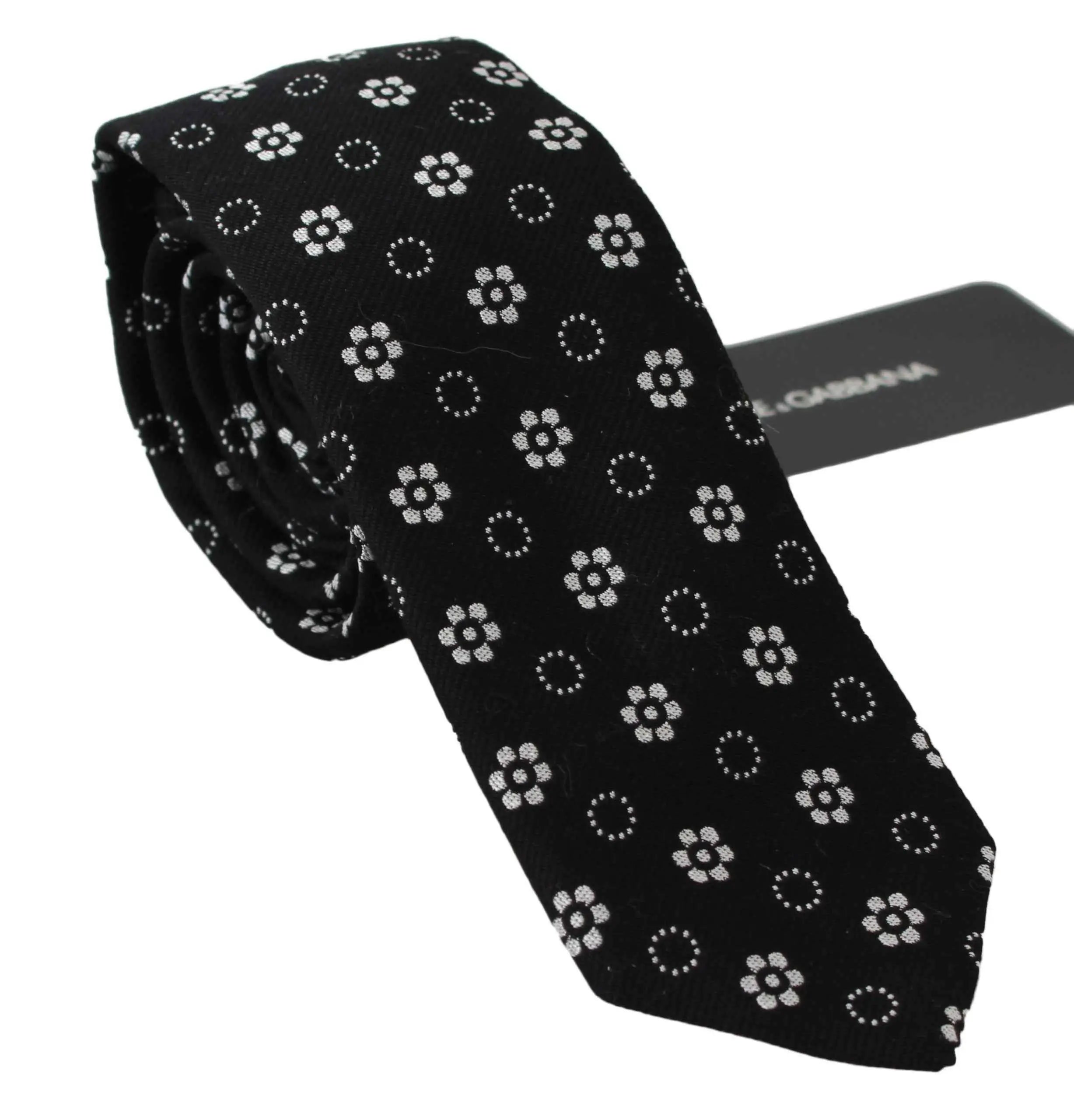 Cravate classique dolce & gabbana en soie noire avec motif floral blanc délicat et étiquette de marque visible