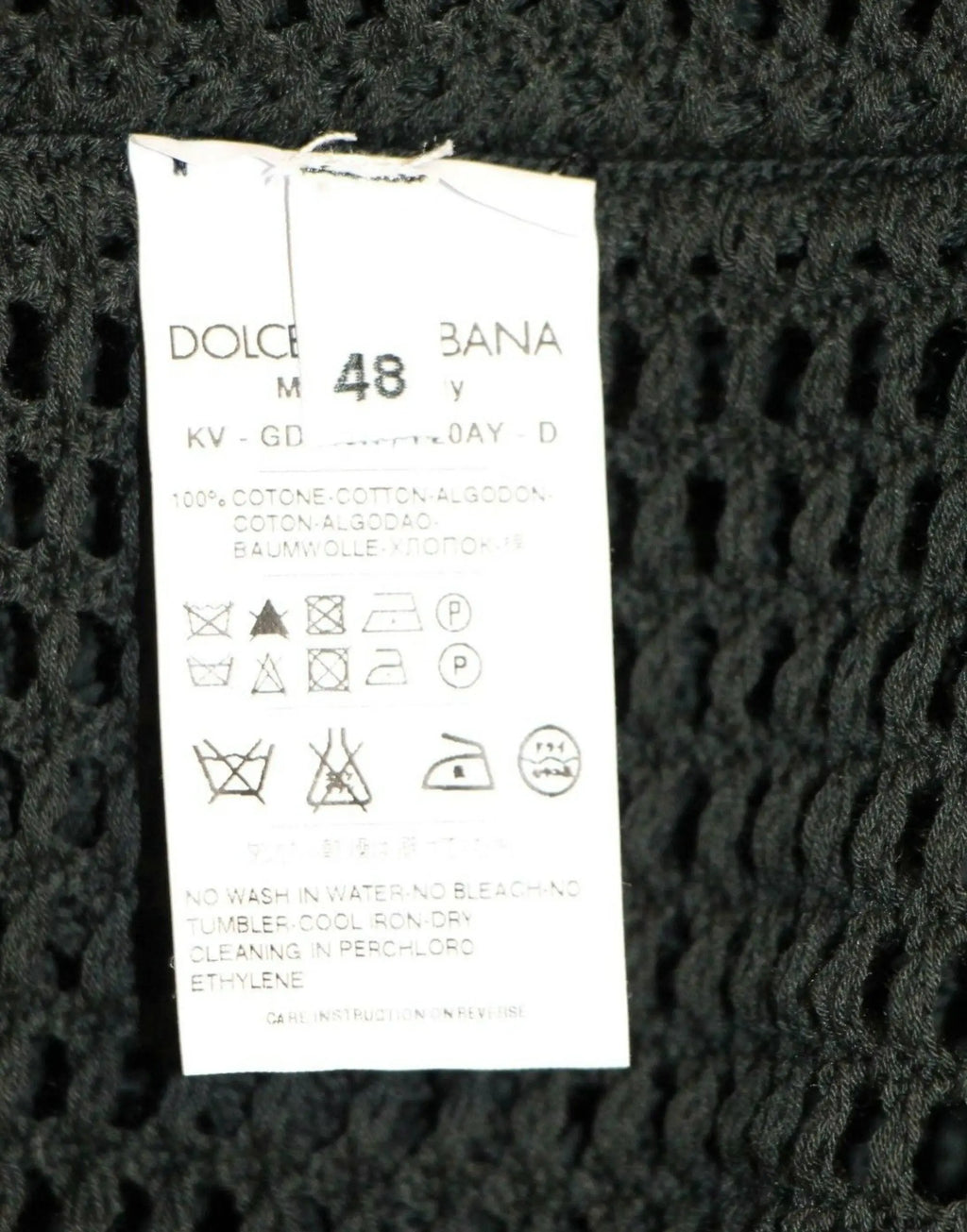 Étiquette d entretien en maille noire au dos du pull en filet vert foncé dolce gabbana avec composition multilingue