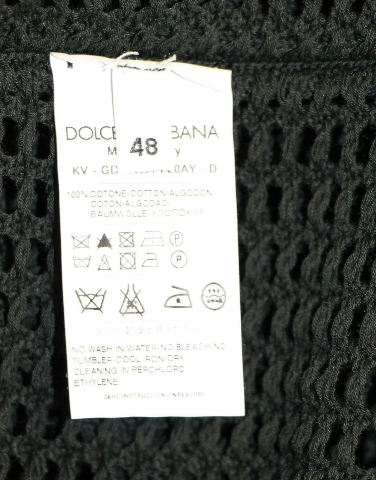 Étiquette d entretien en maille noire au dos du pull en filet vert foncé dolce gabbana avec composition multilingue