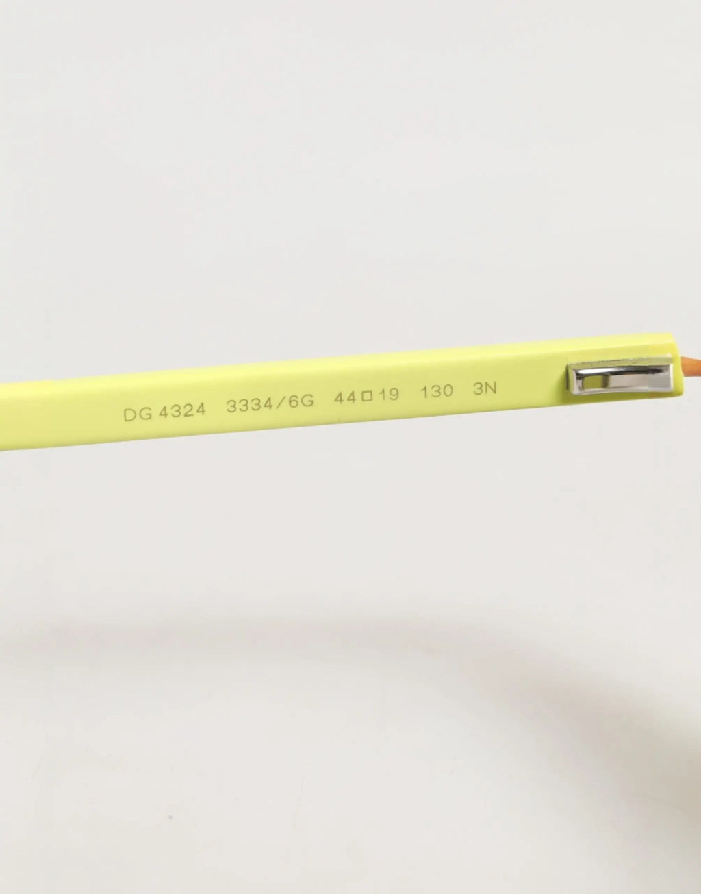 Crayon plastique vert citron avec gomme métal argenté et gravures à côté des lunettes lunettes dolce & gabbana dg4324 jaunes aux verres miroirs