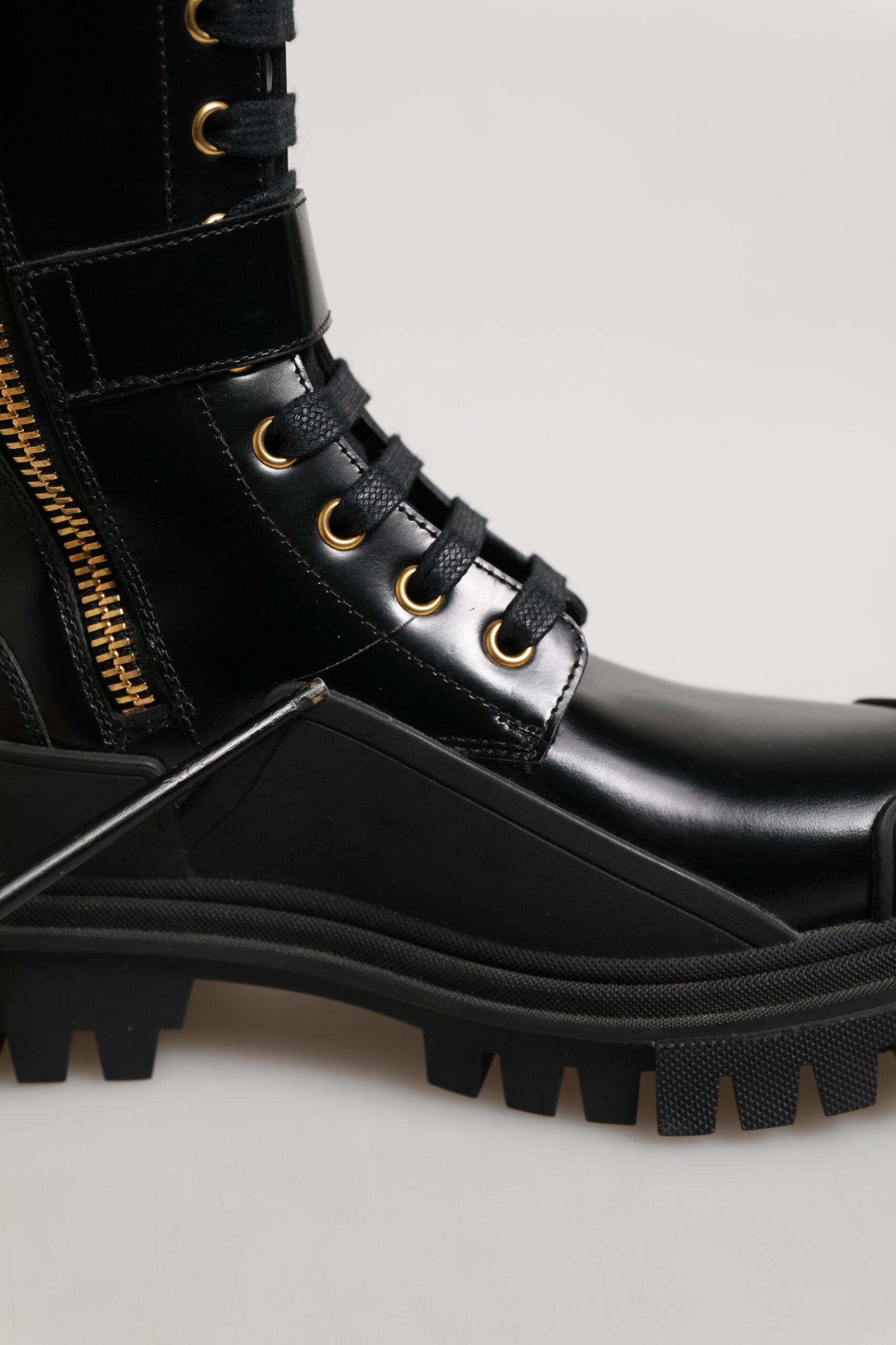 Bottes noires Dolce & Gabbana à boucle ornementale et hauteur genou, en cuir avec détails embellis.