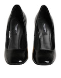 Escarpins Dolce & Gabbana en cuir verni noir et or avec logo doré, semelle élégante et talons hauts sophistiqués.