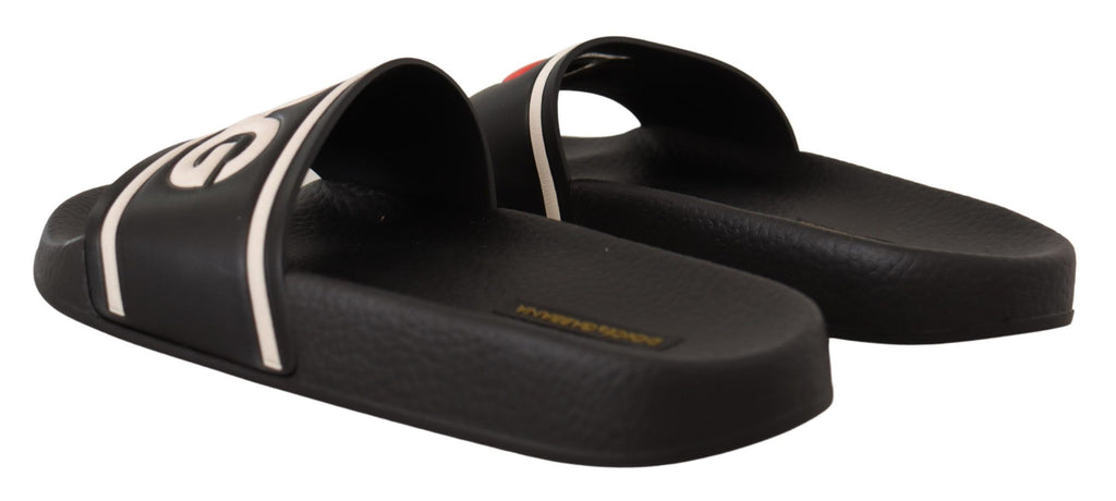 Sandales Dolce & Gabbana en cuir noir avec logo "I Love D&G" sur le dessus, style slides, visibles en détail.