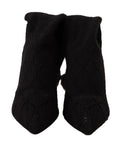 Chaussettes noires extensibles Dolce & Gabbana, portées avec bottines hautes, vues de devant sur un fond neutre.