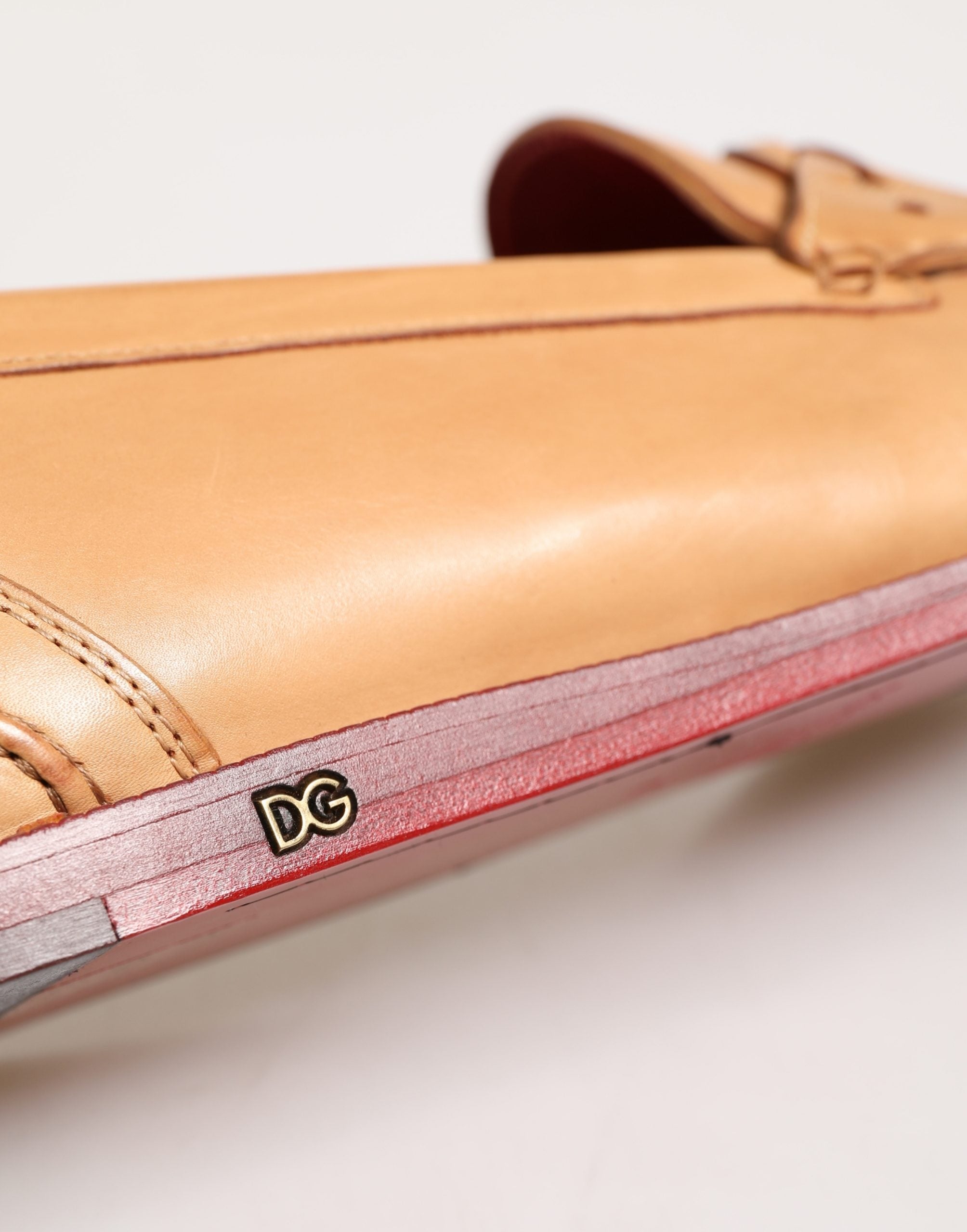Chaussures mocassins homme Dolce & Gabbana en cuir beige avec pampilles, design slip-on élégant et décontracté.