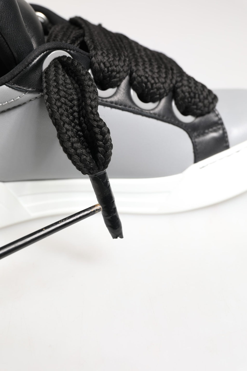 Chaussures sneakers basses en cuir gris de Dolce & Gabbana avec lacets, style élégant et moderne.