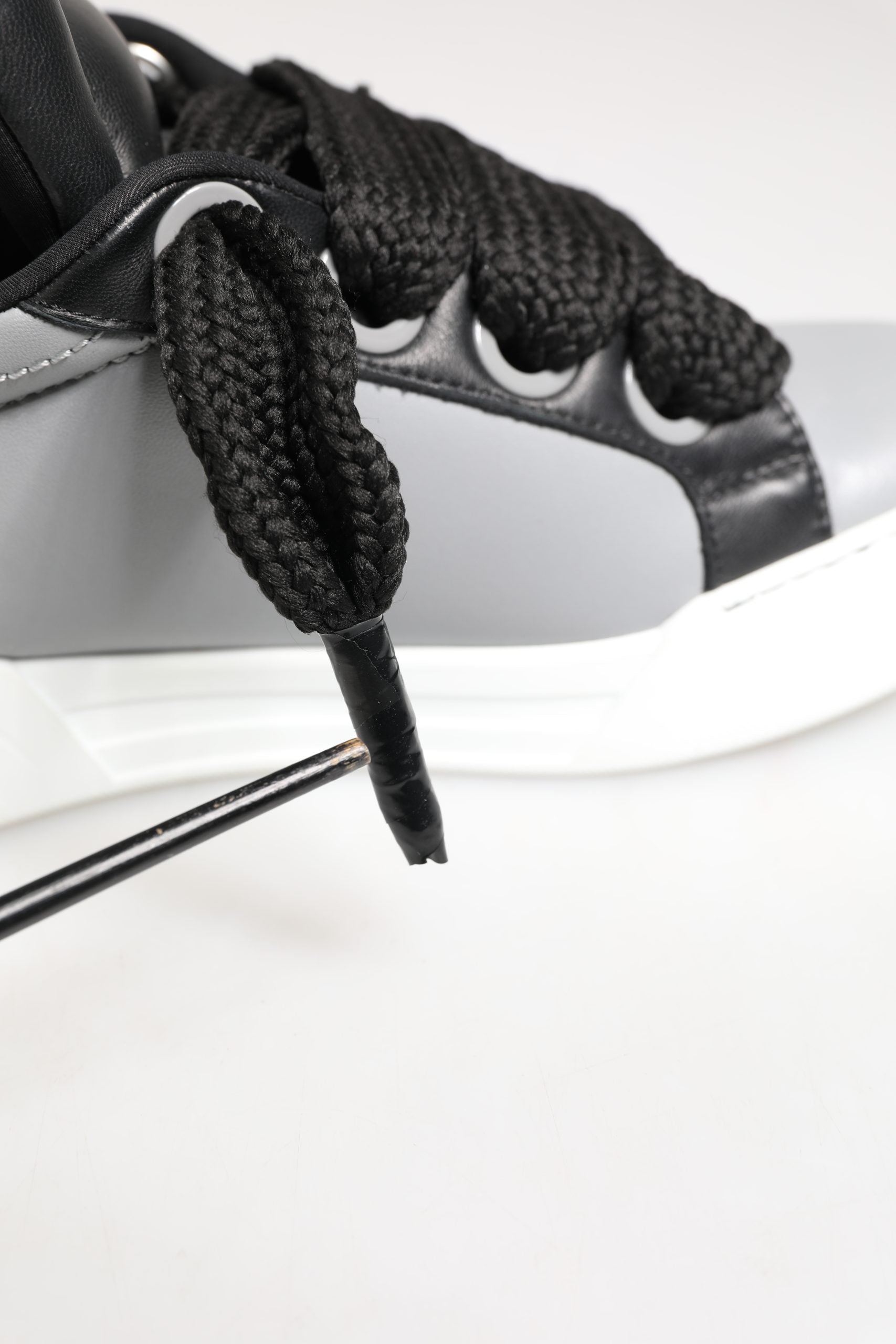 Chaussures sneakers basses en cuir gris de Dolce & Gabbana avec lacets, style élégant et moderne.