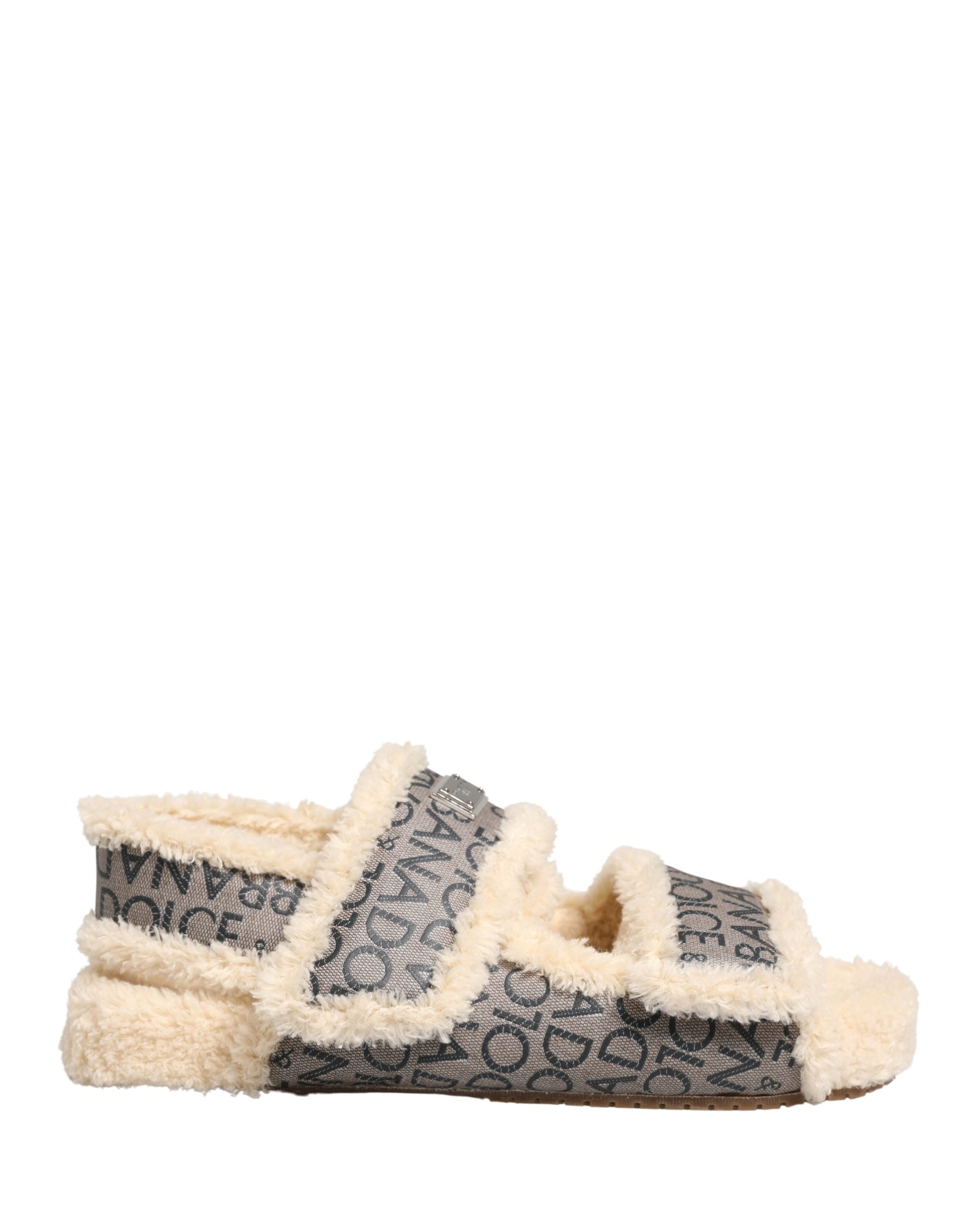 Sandales plates Dolce & Gabbana en fausse fourrure beige avec logo, confortables, parfaites pour un style chic et décontracté.