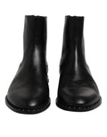 Bottines en cuir noir Dolce & Gabbana avec logo, clous décoratifs et semelle en caoutchouc, vue de face sur fond blanc.