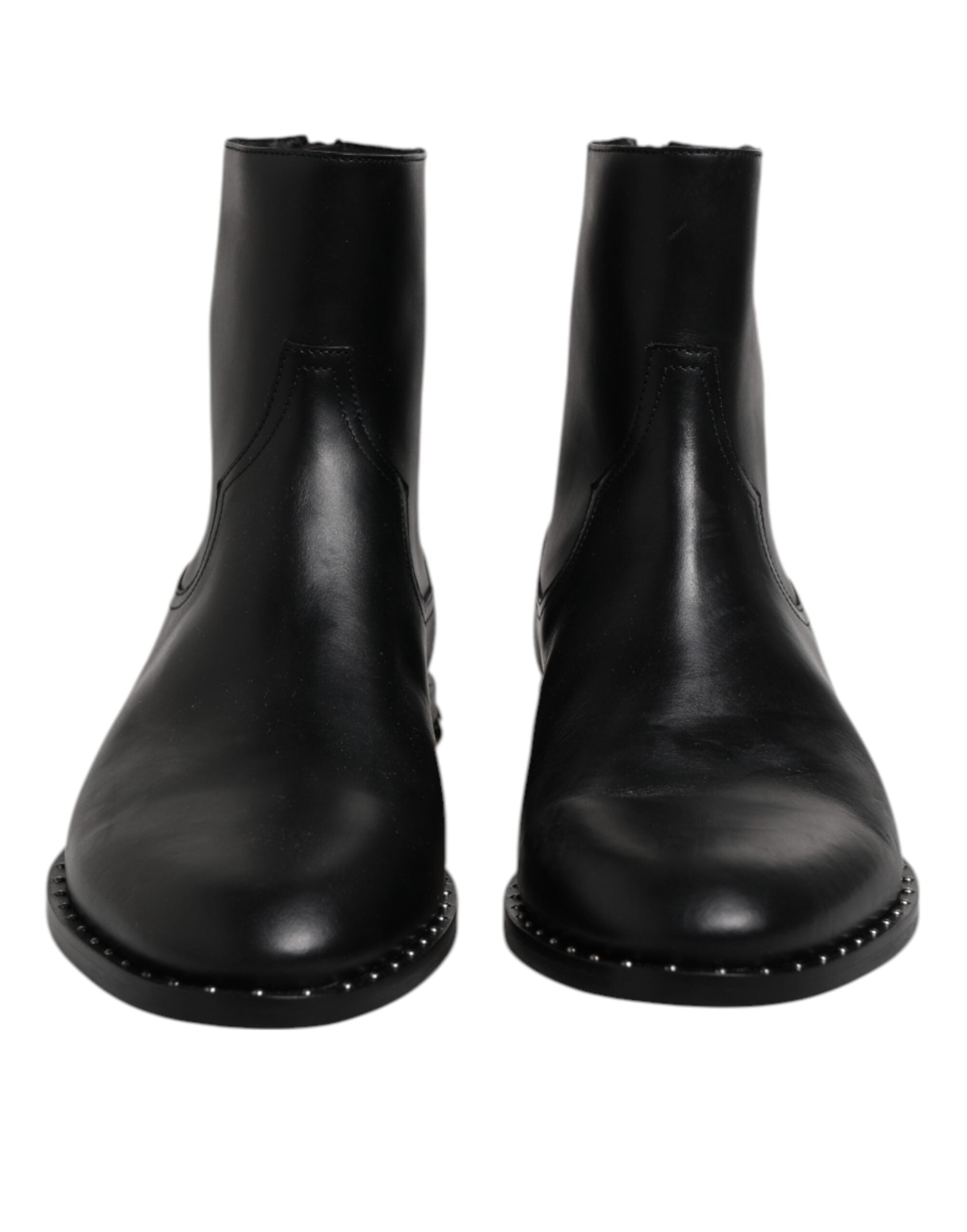 Bottines en cuir noir Dolce & Gabbana avec logo, clous décoratifs et semelle en caoutchouc, vue de face sur fond blanc.