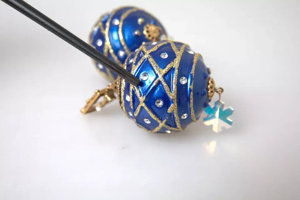Boucles doreilles clip on dolce & gabbana en laiton doré bleu avec œuf ornemental strass et charme flocon de neige pendentif