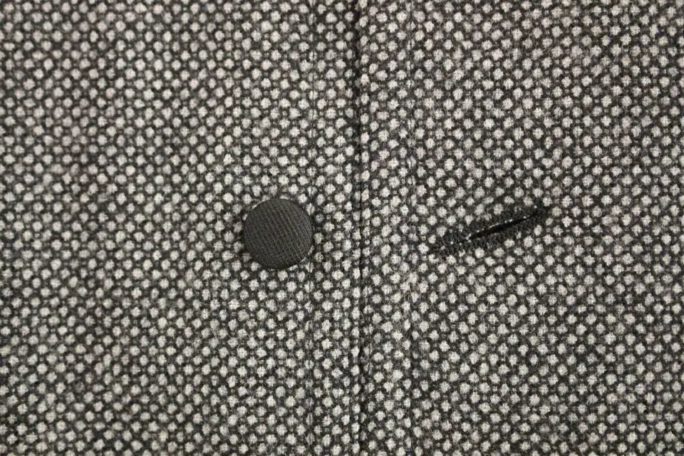 Bouton gris foncé texturé sur gilet dolce & gabbana en mélange de coton avec tissu à pois blancs fins