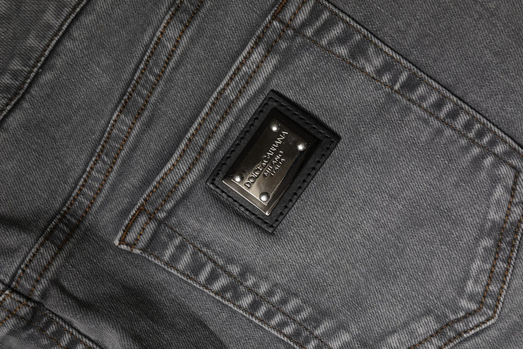 Jupe courte en denim gris dolce & gabbana en coton stretch taille mi-haute avec patch cuir noir et clous argentés au dos