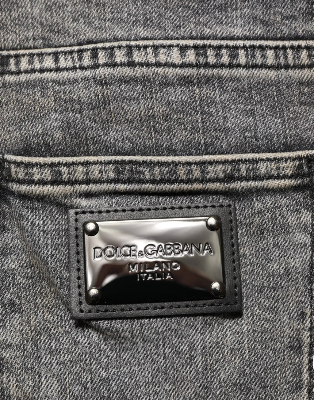 Plaque métallique argentée avec bordure en cuir noir et rivets sur jean slim gris en coton extensible dolce gabbana