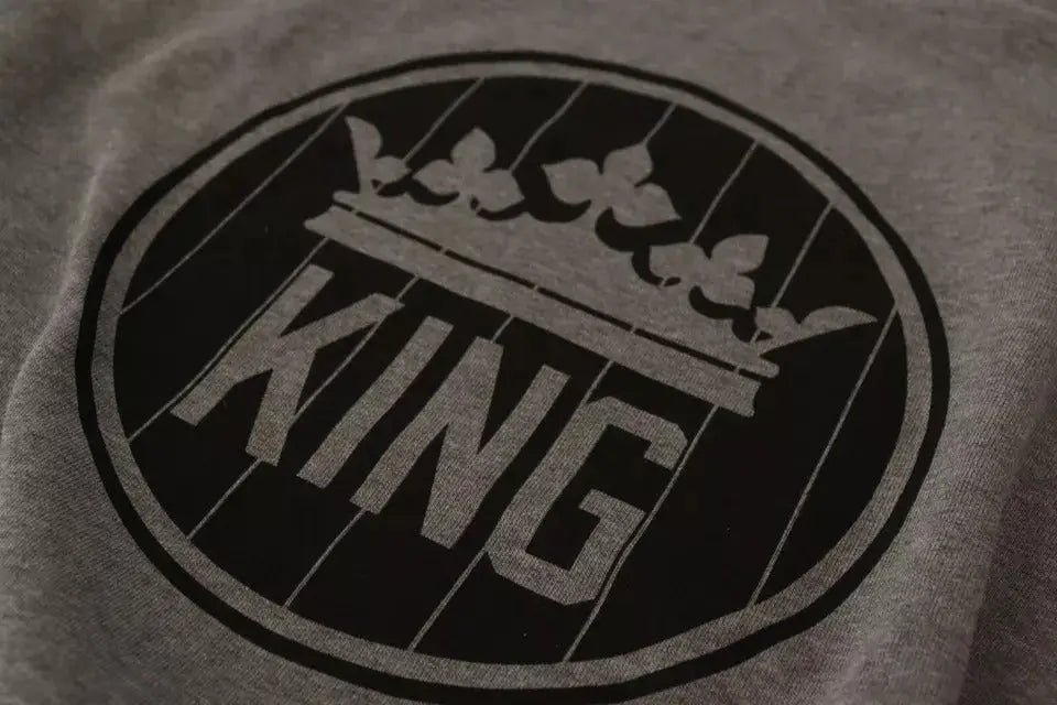 Dolce & gabbana pull en coton gris heathered avec logo circulaire noir et lettrage king sous une couronne stylisée