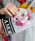 Accessoire floral vibrant rose et blanc avec centre doré en tissu sur pull dolce & gabbana gray dg amore queen