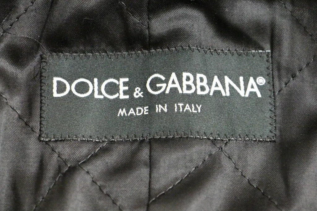 Image de tissu matelassé noir avec étiquette cousue dolce & gabbana made in italy sur manteau gris à double boutonnage