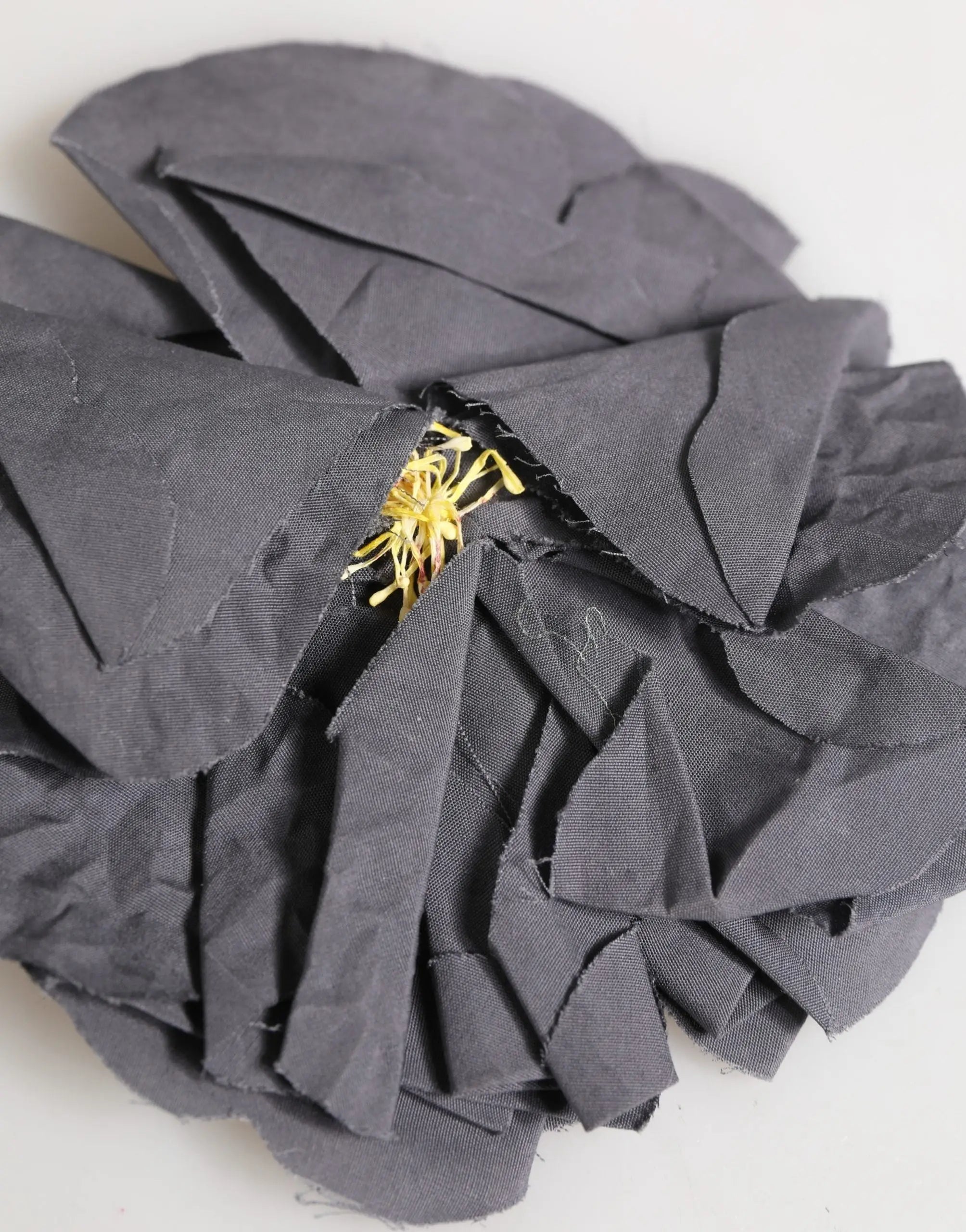 Dolce & gabbana broche tissu popeline mélangé en soie gris avec fleur tissu foncé aux pétales superposées et centre jaune