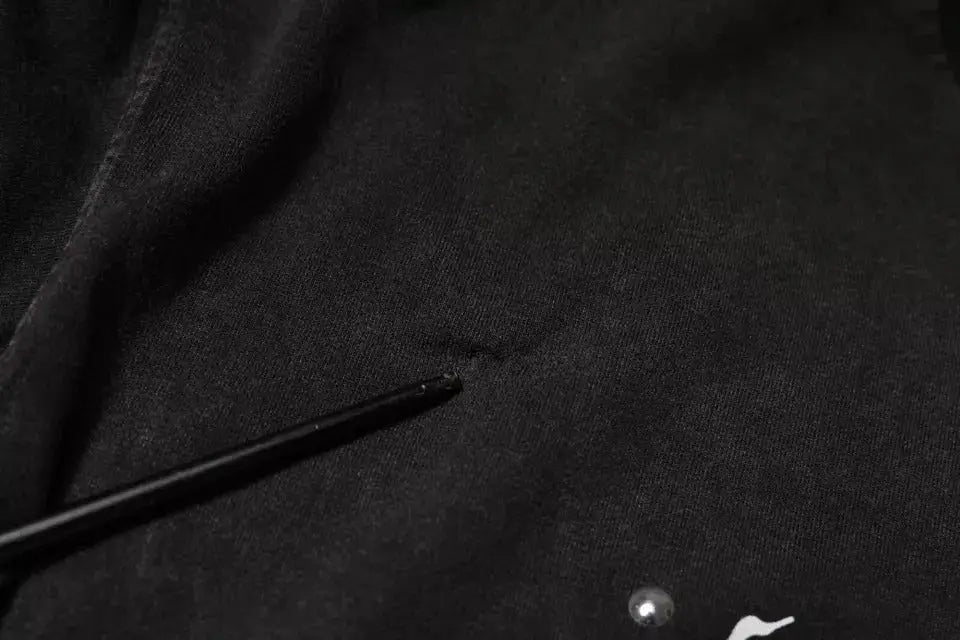 T-shirt dolce & gabbana gris avec imprimé léopard en coton et logo blanc sur tissu noir avec un stylo noir posé