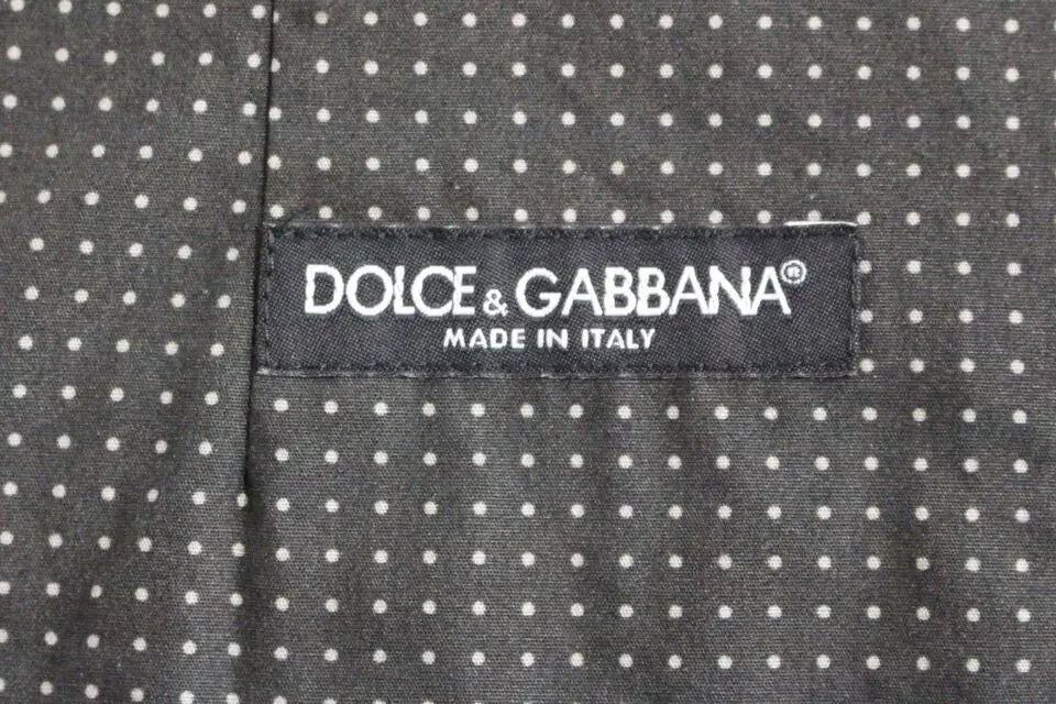Étiquette noire dolce & gabbana avec texte blanc sur tissu gris à pois pour veste sans manches polka dot