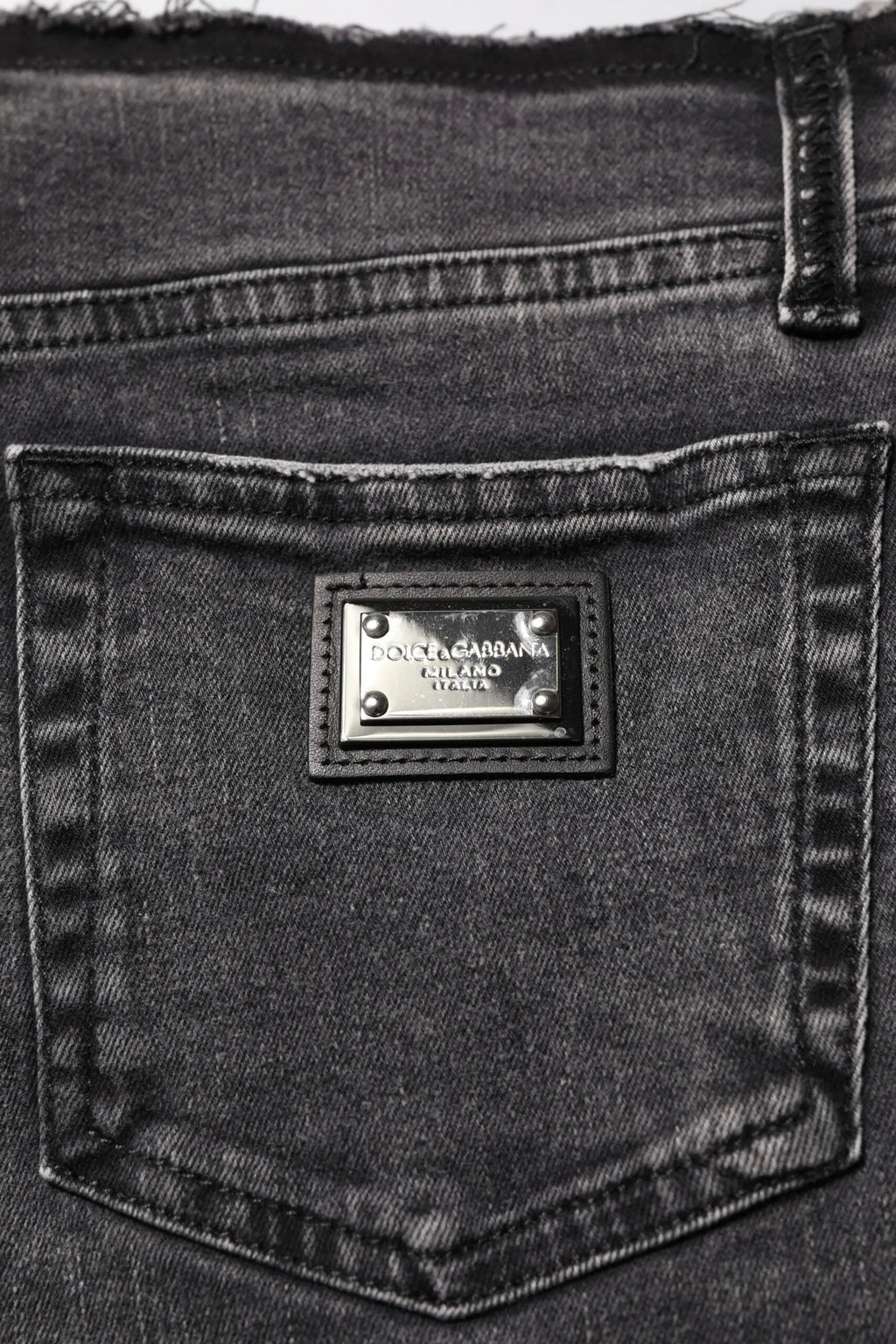 Jean en denim noir dolce gabbana avec plaque métallique argentée gravée dolce gabbana cutland italy