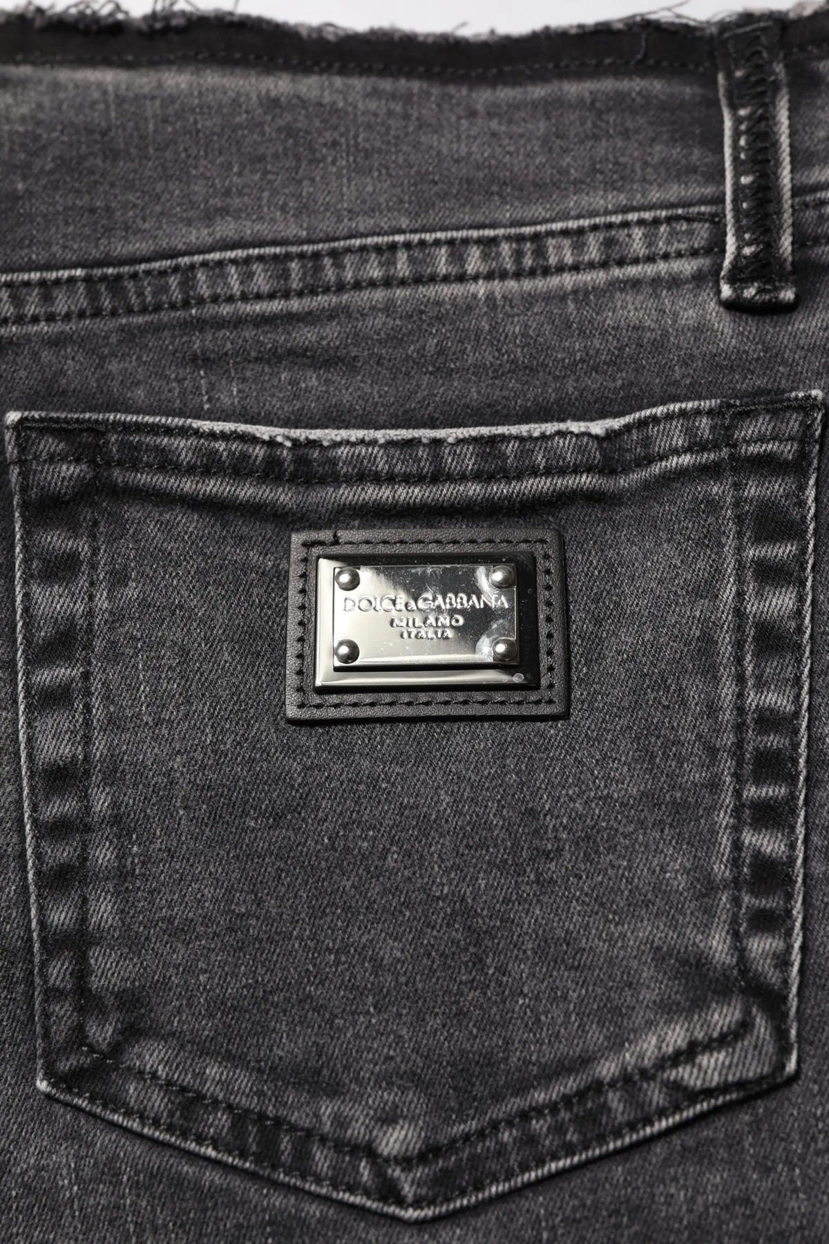 Jean en denim noir dolce gabbana avec plaque métallique argentée gravée dolce gabbana cutland italy