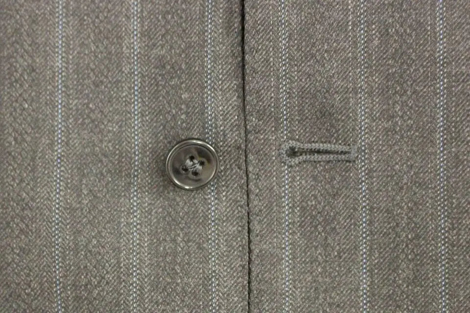 Bouton quatre trous argenté sur tissu gris à chevrons avec fines rayures verticales sur gilet en laine dolce gabbana