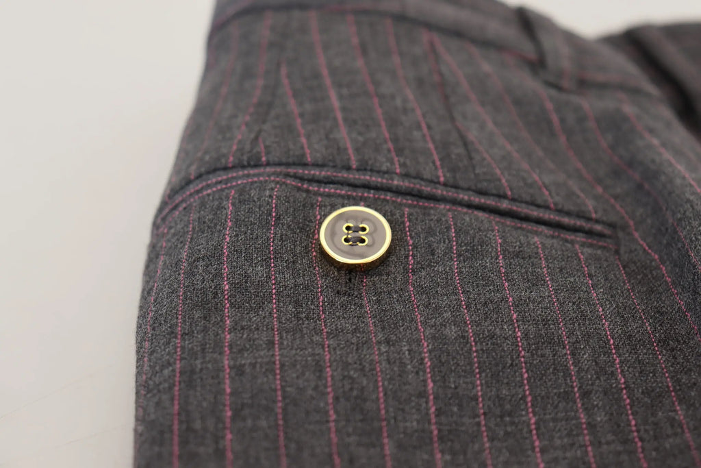 Un bouton doré à quatre trous avec un éclat subtil centré sur un tissu gris foncé à rayures des pantalons en laine dolce & gabbana femme