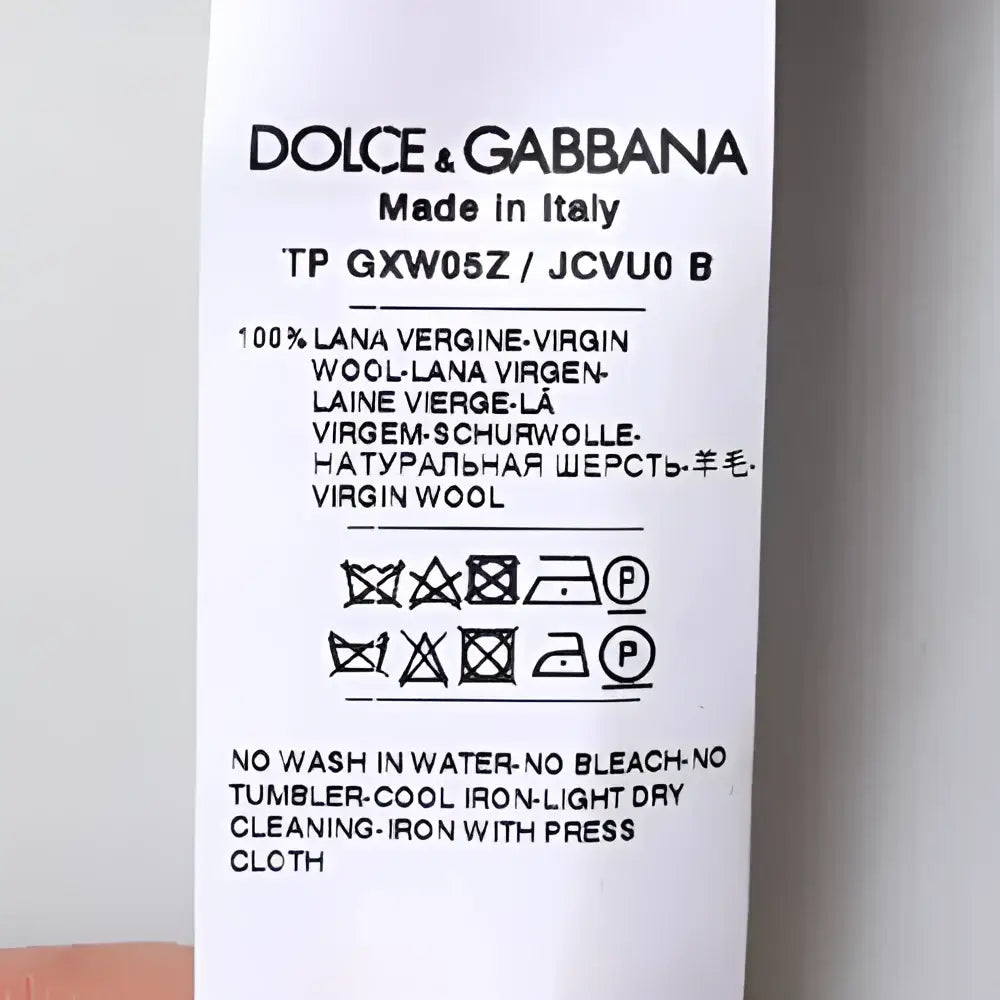 Label dolce & gabbana indiquant un pull col roulé gris en laine vierge 100 % fabriqué en italie