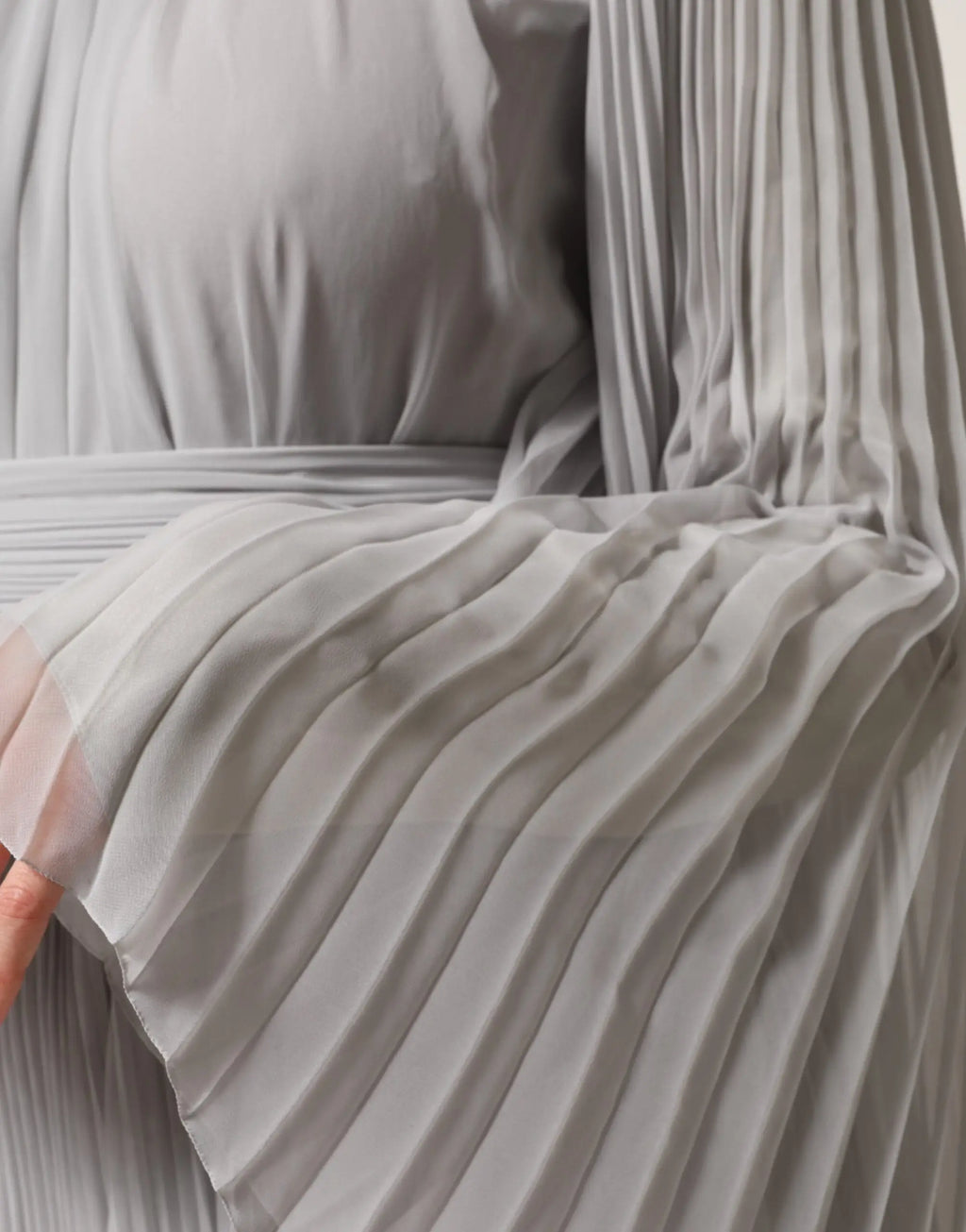 Une robe longue plissée gris clair en mélange de soie dolce gabbana avec manches longues et tissu fluide doux