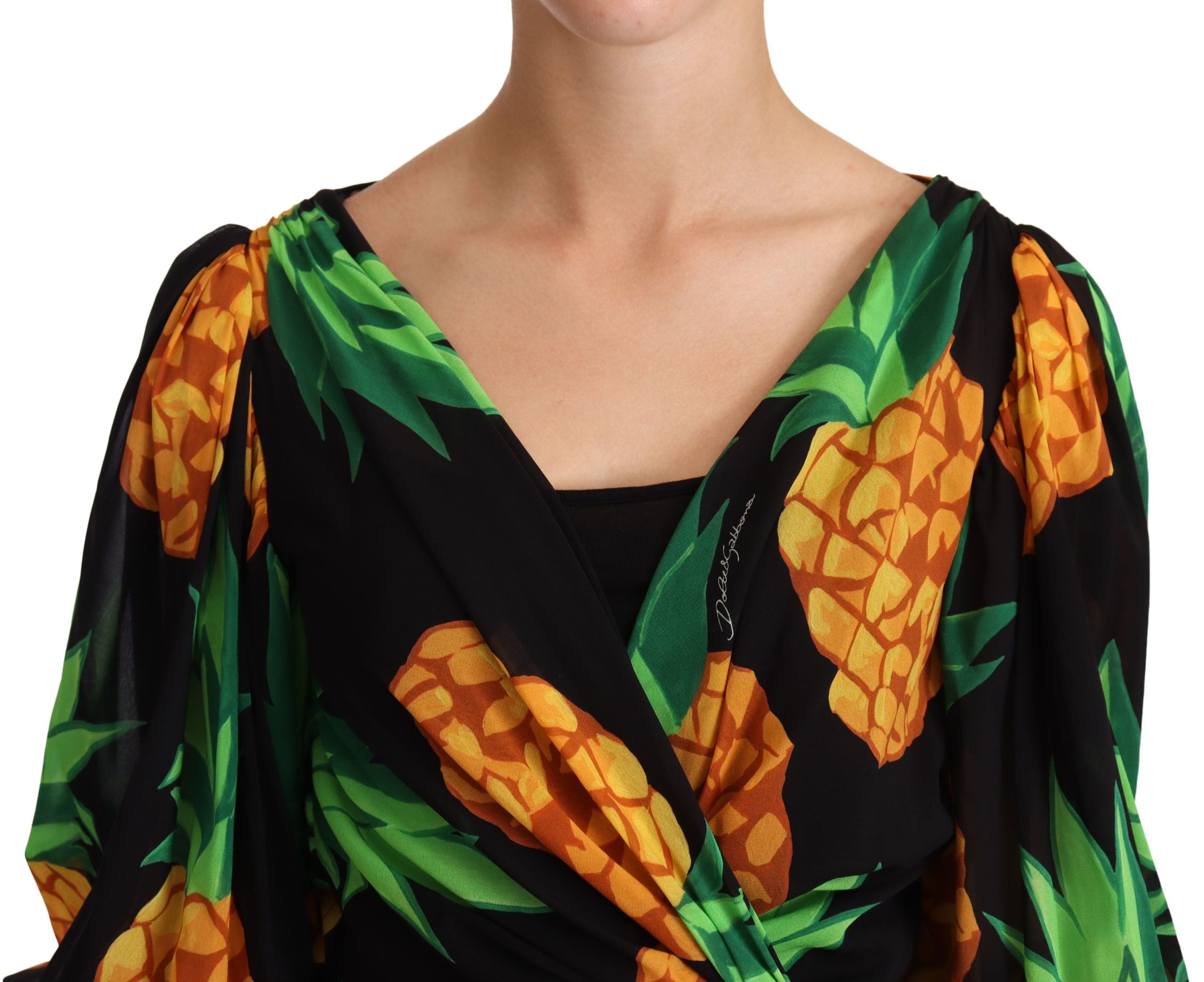 Robe noire Dolce & Gabbana en soie stretch avec imprimé ananas, coupe en wrap élégante et détails sophistiqués.