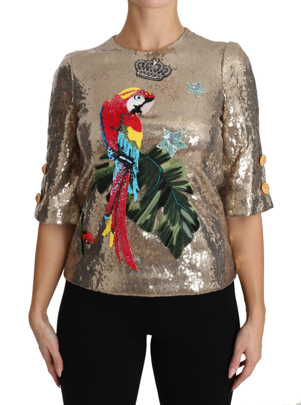 Blouse en cristal doré avec motif perroquet à sequins de Dolce & Gabbana, détail élégant et brillant sur fond de tissu léger.