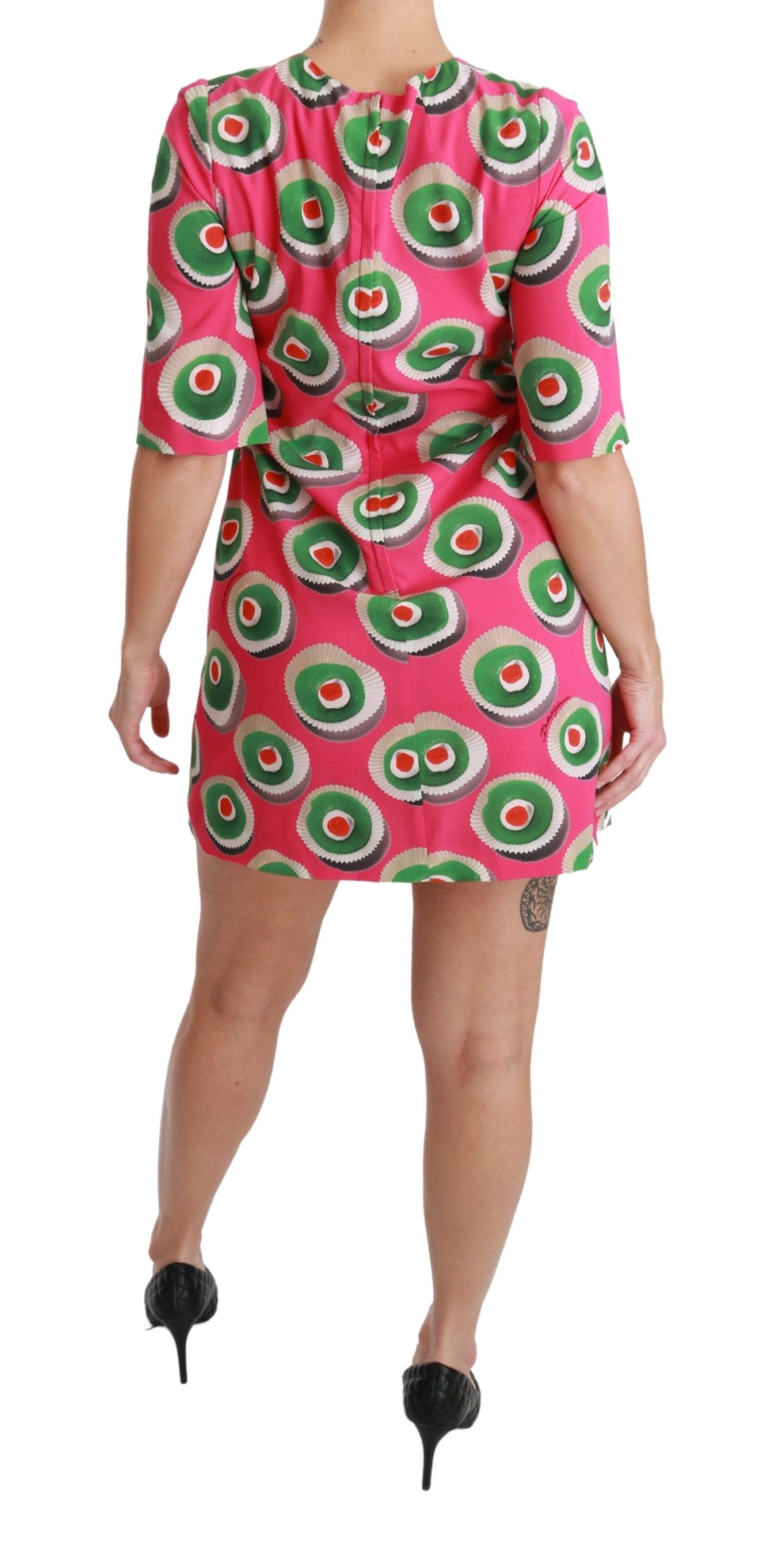 Robe Dolce & Gabbana en soie rose, coupe cupcake, ajustée et fluide, portée sur un fond neutre.