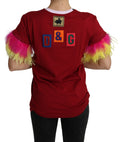 T-shirt Dolce & Gabbana rouge avec imprimé de cochon, manches en plumes et style décontracté visible sur l'image.