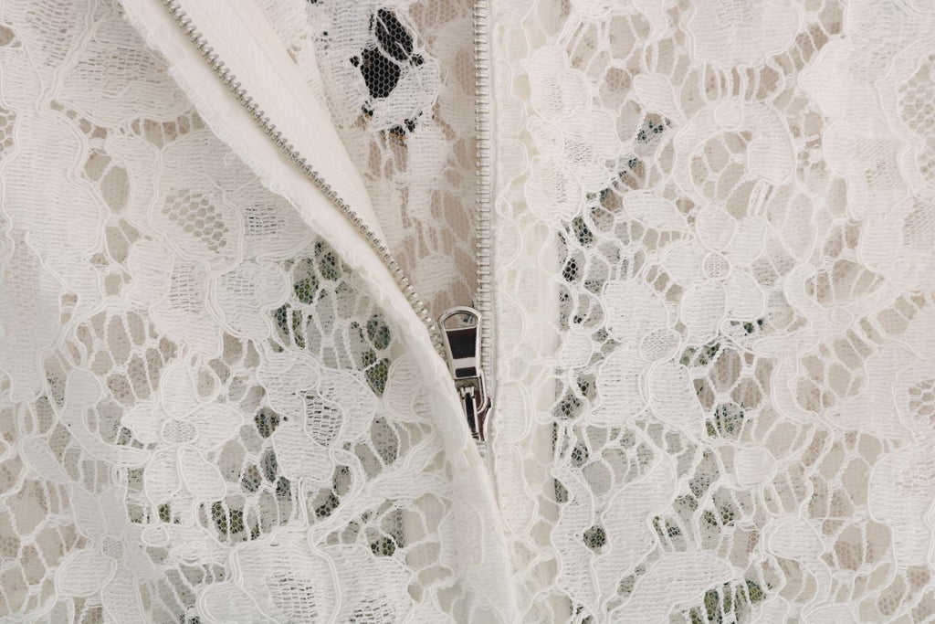 Blouse en dentelle blanche Dolce & Gabbana ornée de cristaux, élégante et raffinée, visible en gros plan.