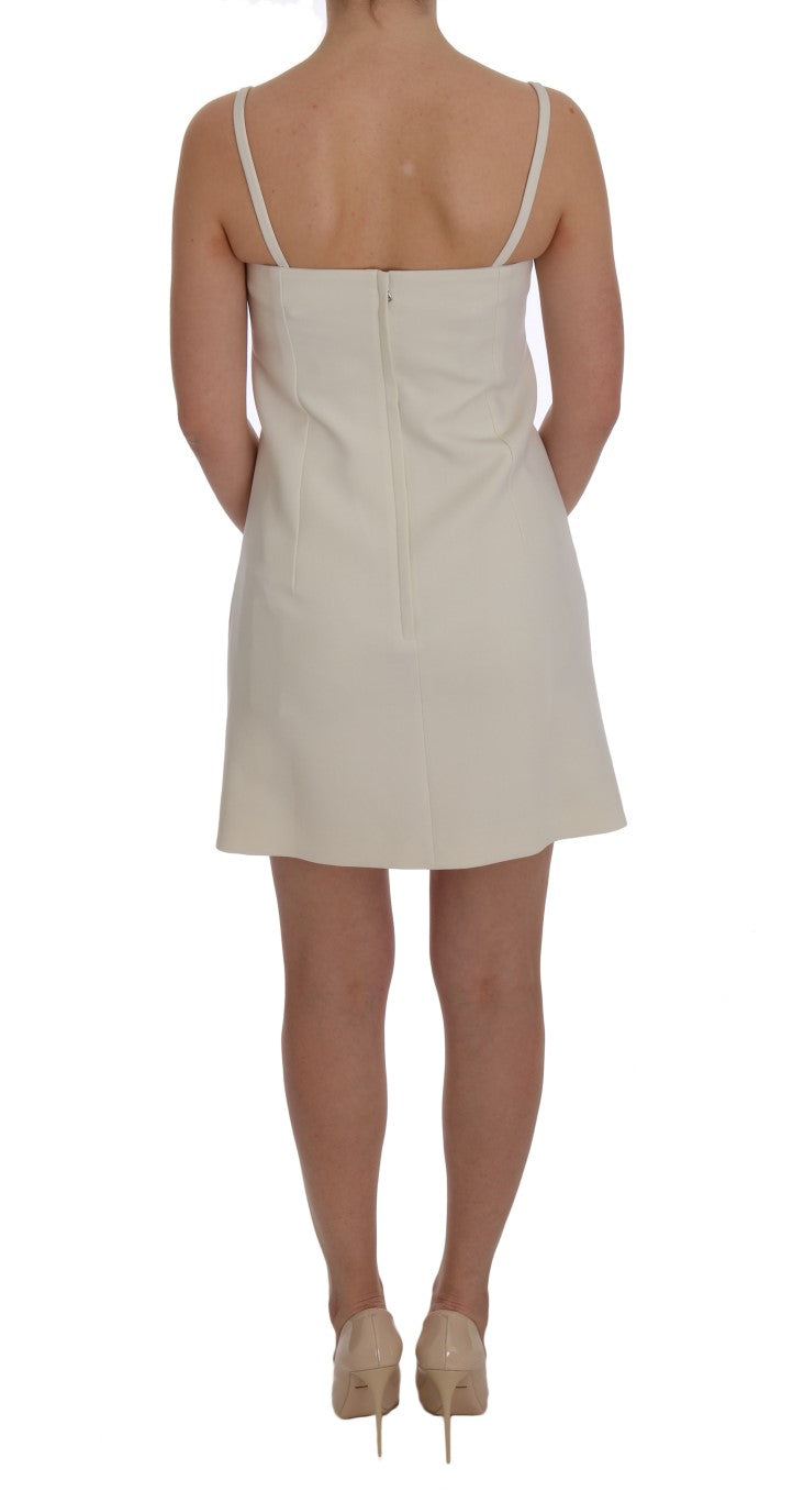 Robe blanche en laine extensible de Dolce & Gabbana avec broche, coupe shift élégante et design sophistiqué.