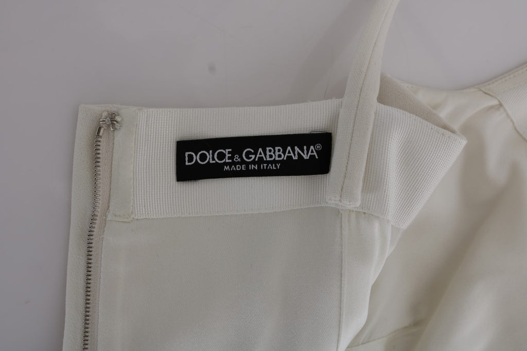 Robe blanche en laine stretch de Dolce & Gabbana avec broche élégante, coupe shift et détails raffinés.