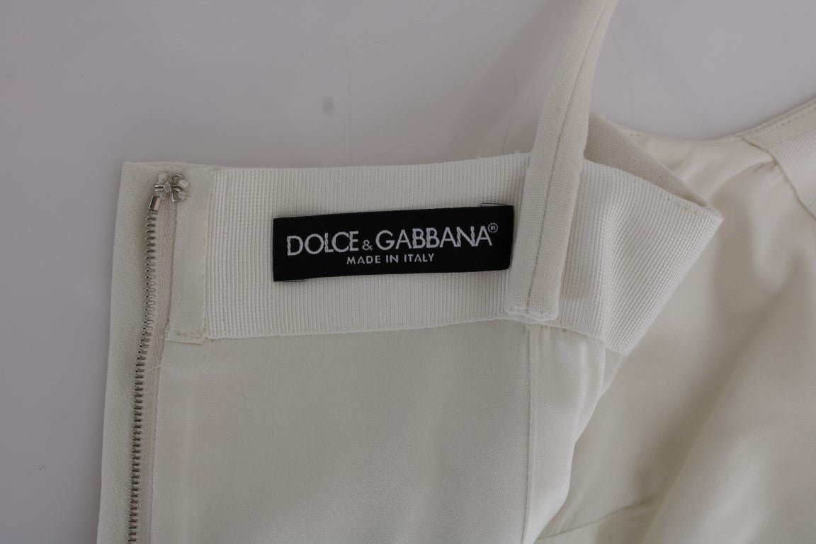 Robe blanche en laine stretch de Dolce & Gabbana avec broche élégante, coupe shift et détails raffinés.