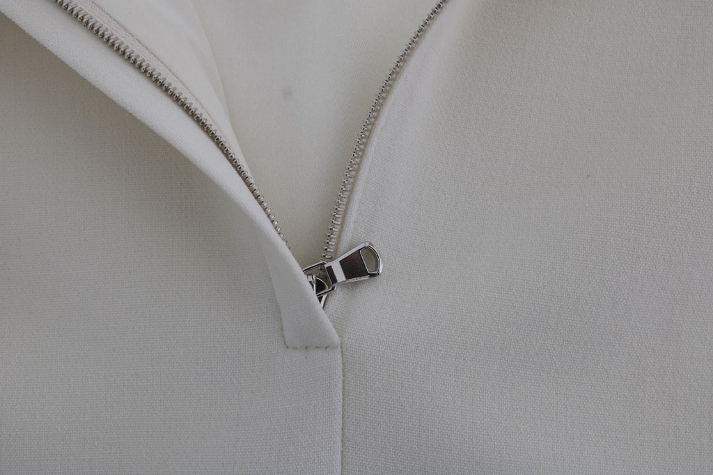 Robe blanche en laine extensible de Dolce & Gabbana, style chemise avec broche élégante, vue de face.